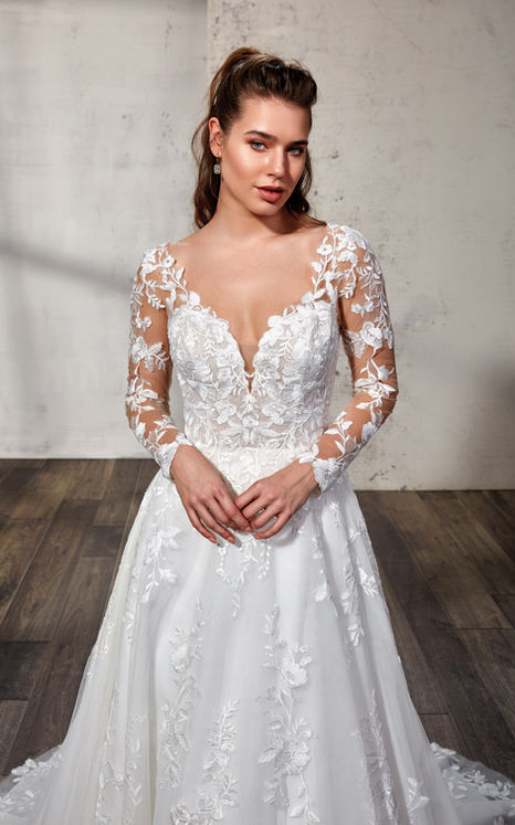 woman wearing Eddy K bridal A-Line long sleeve wedding gown with ivory lace and sequins over tulle