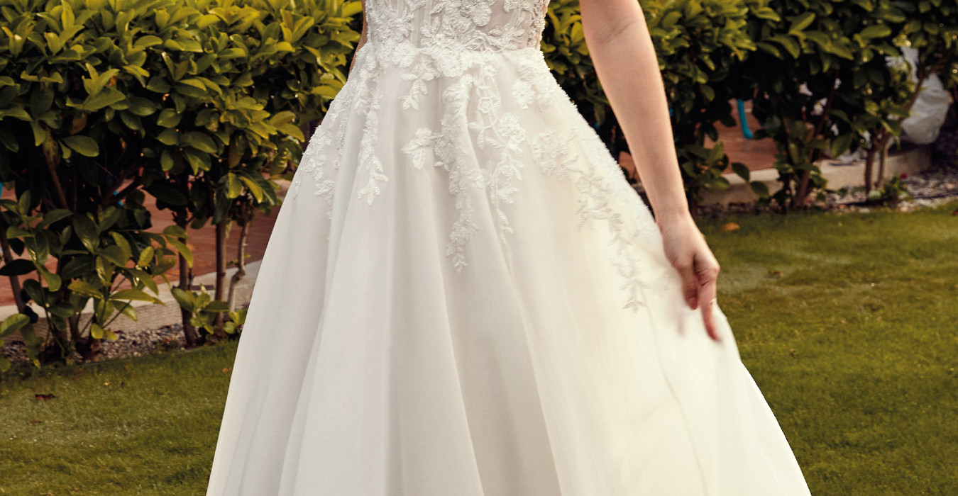 Eddy K ivory A-Line wedding gown with lace details on bride at a garden wedding