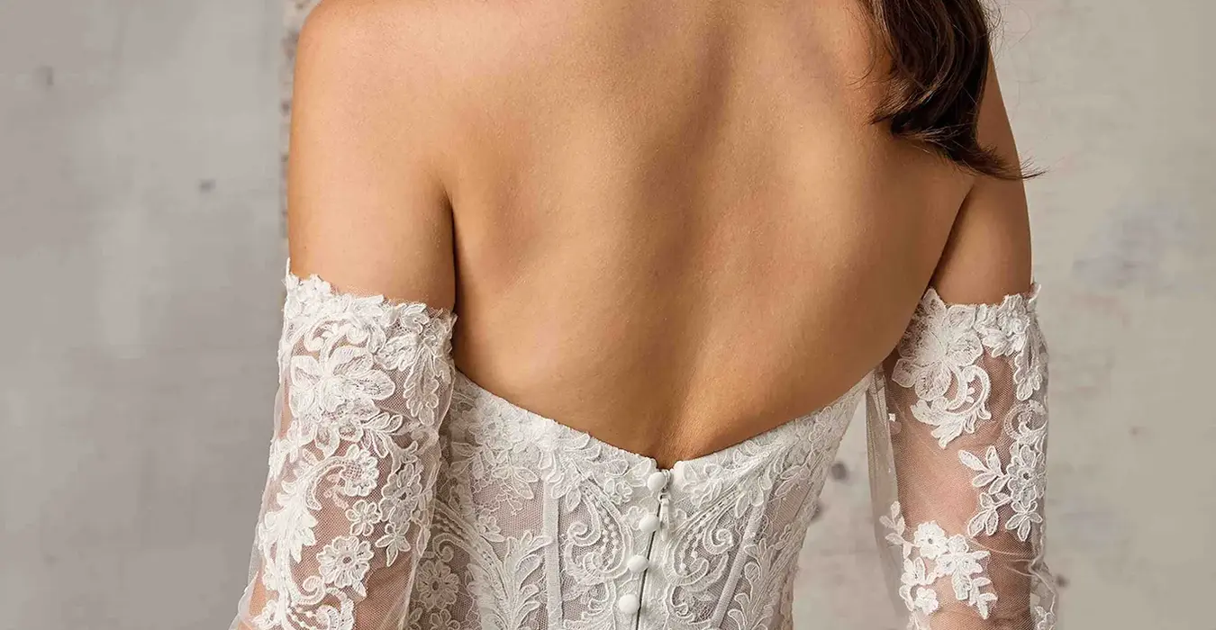Close up back of Eddy K crêpe a-line wedding dress with a sweetheart neckline and a strapless body on a bridal model posing in a bridal studio.