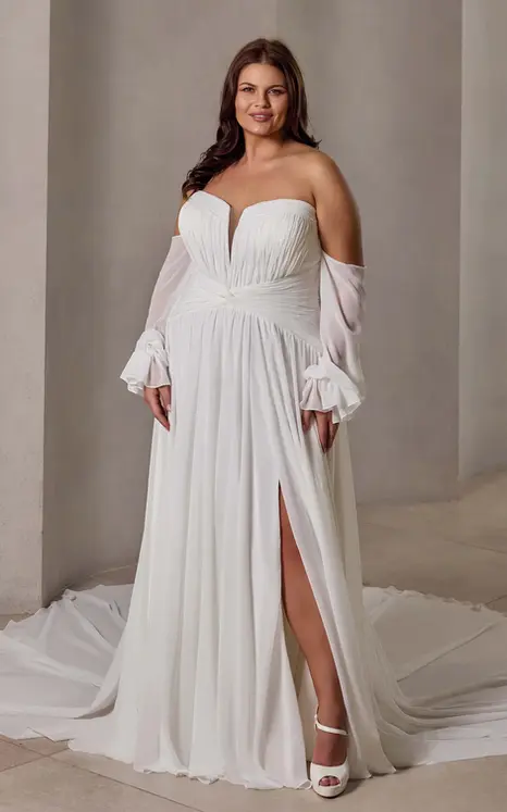 Eddy K chiffon a-line wedding dress with a sweetheart neckline and a strapless bodice on a bridal model standing in an elegant studio.