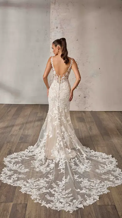 Back of Eddy K lace and tulle fit-n-flare wedding dress with a v-neck neckline and a sleeveless body on a bridal model standing in a bridal studio.