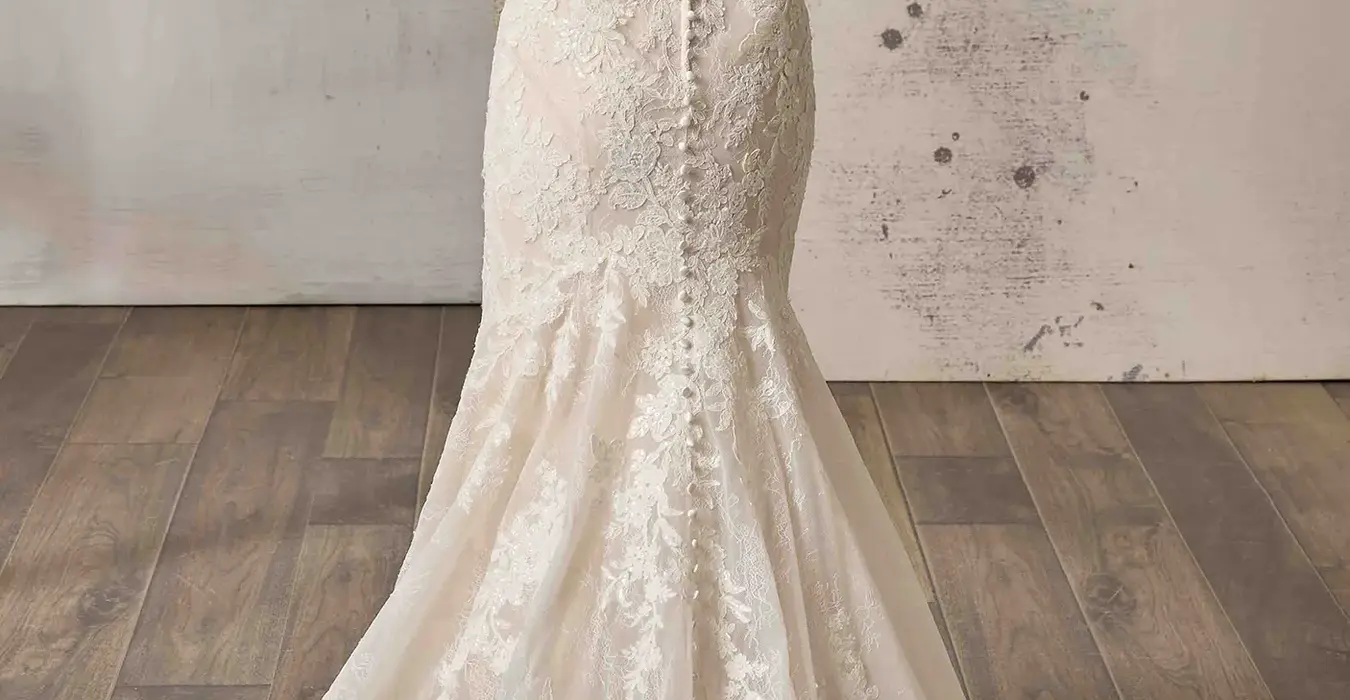 Back of Eddy K lace fit-n-flare wedding dress with a straight neckline and a sleeveless body on a bridal model standing in a bridal studio