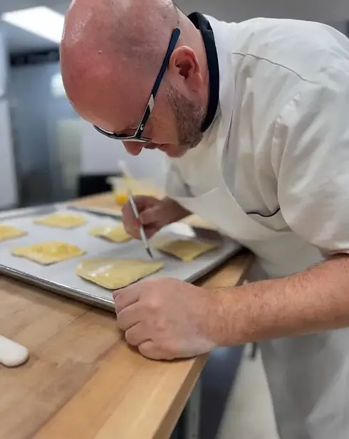 Baker preparing apple turnover at Croissant Gourmet Orlando