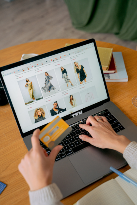 Woman shopping online with credit card and laptop for clothes.