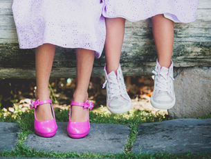 Photo of two daughters' shoes as their legs dangle