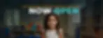 A young girl smiles in a preschool classroom