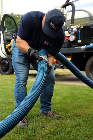 Technician connecting hose for septic tank pumping