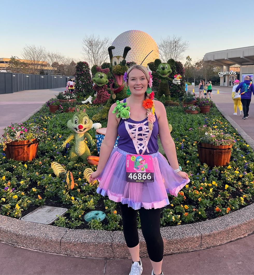 A smiling woman dressed in a Rapunzel-inspired running outfit poses in front of a colorful flower bed at EPCOT during the RunDisney Princess Half Marathon Weekend. She wears a purple corset-style top with a pink ribbon lace-up front, a layered purple tutu, black leggings, and a race bib numbered 46866 with her name, Kristen. Her outfit is accessorized with a floral hairpiece, a Pascal plush from Tangled on her shoulder, and a flower lei. Behind her, topiaries of Pluto, Mickey, and Minnie Mouse decorate the garden with Spaceship Earth visible in the background. The setting captures the early morning race atmosphere with fellow runners in bright costumes walking by.
