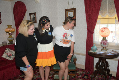 Castle Coaches Travel team members including owner Colette Spirer inside Walt's famous apartment during Walt's Main Street Story, a guided tour at Disneyland Park. Agents are looking at the famous lamp, which is kept on at all times to keep Walt's spirit alive.