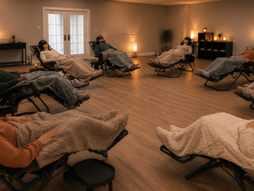Participants resting in zero-gravity recliner chairs under blankets during a guided Hemi-Sync session at an Exploring Consciousness workshop