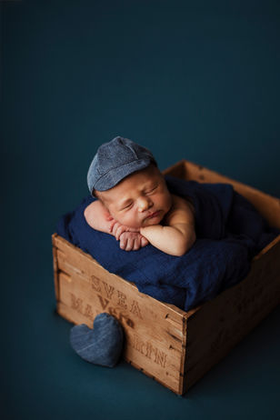 Lisa Granboms foto. Nyföddfotografering pojke med blå bakgrund