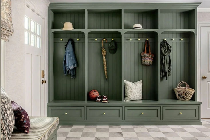 Mudroom with patterned tile flooring and built-in bench providing practical entryway storage for residential homes