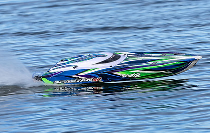 Traxxas Spartan SR with a blue, white, and green pattern speeding across water