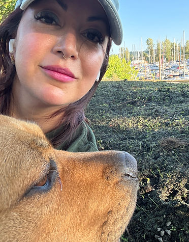 A caring female dog sitter on Hayden Island smiling while petting a happy dog.