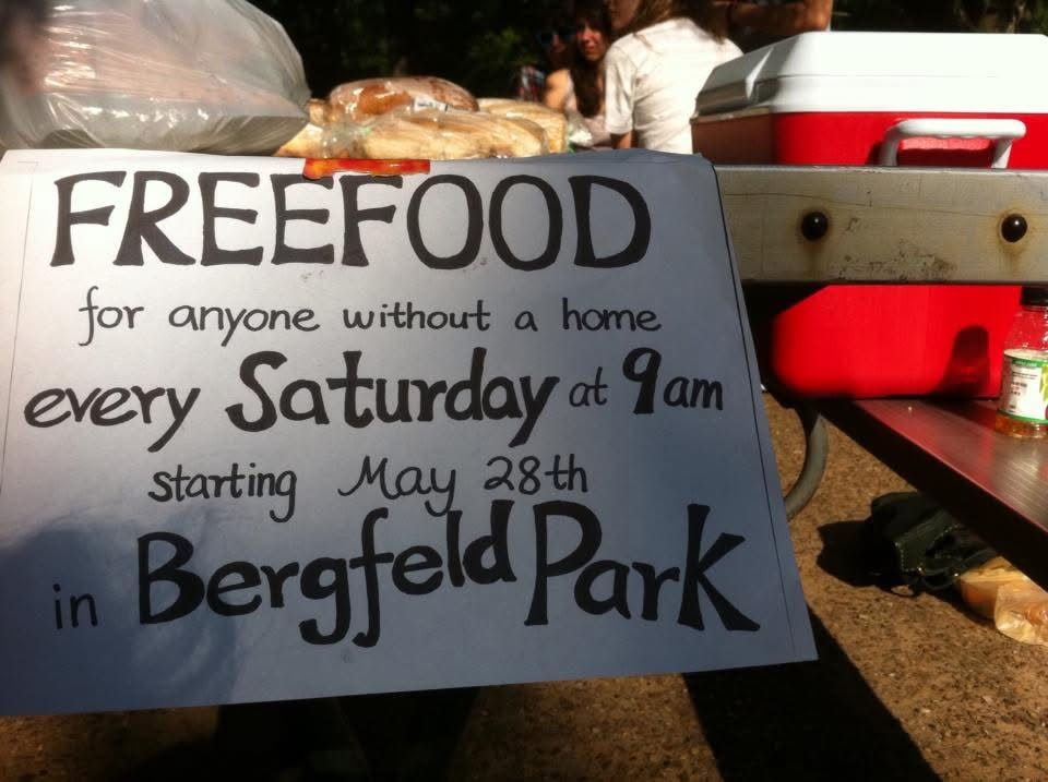 Handwritten sign at Bergfield Park reasd: Free Food for anyone without a home every Saturday at 9 am stating May 28th in Berfield Park", marking the launch of Hunger for Love in 2011.