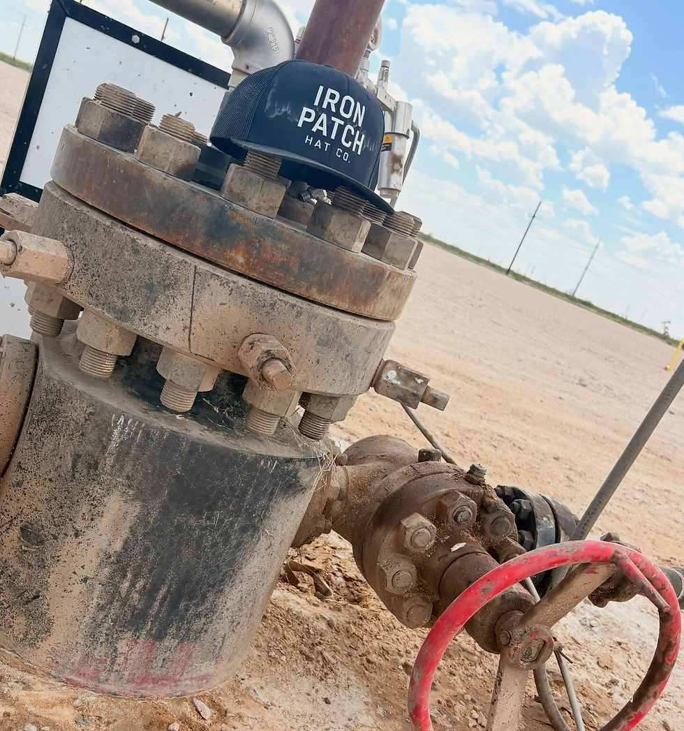 Iron Patch Hat Co. cap resting on a rusted oilfield wellhead valve in a dusty East Texas field