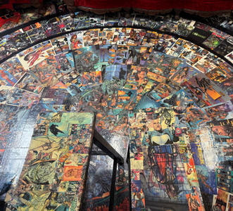 Tattoo studio floor covered in a collage of colorful comic book pages, creating a unique artistic design throughout the space.