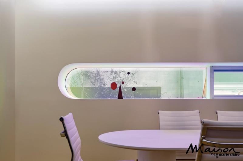 The window in the first-floor lobby was designed based on the initials of the company name, VEAM. Made with dichroic glass, it changes color as the light shifts.