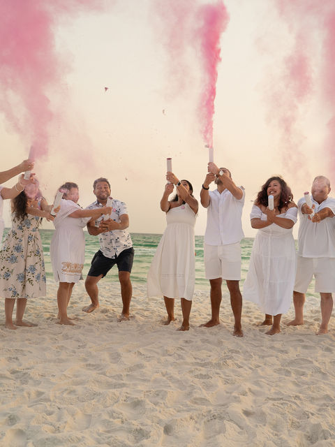 Beautiful portrait of a family during a photo shoot at the beach for a gender reveal