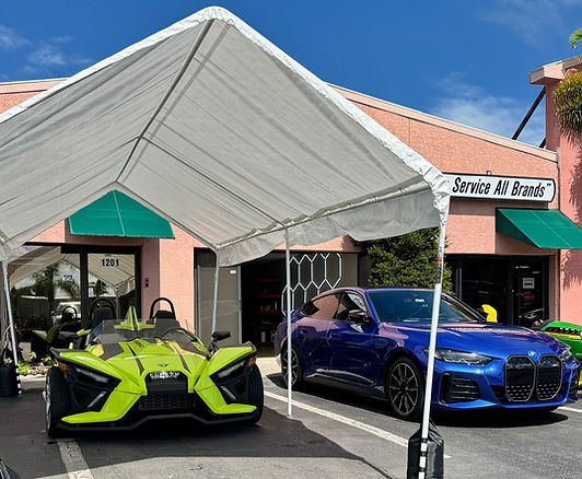 Front of Store for American Motor Detail with a yellow slingshot and a portobello blue BMW I4 M50