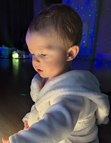 Baby in a white robe at a baby massage Atherstone spa.