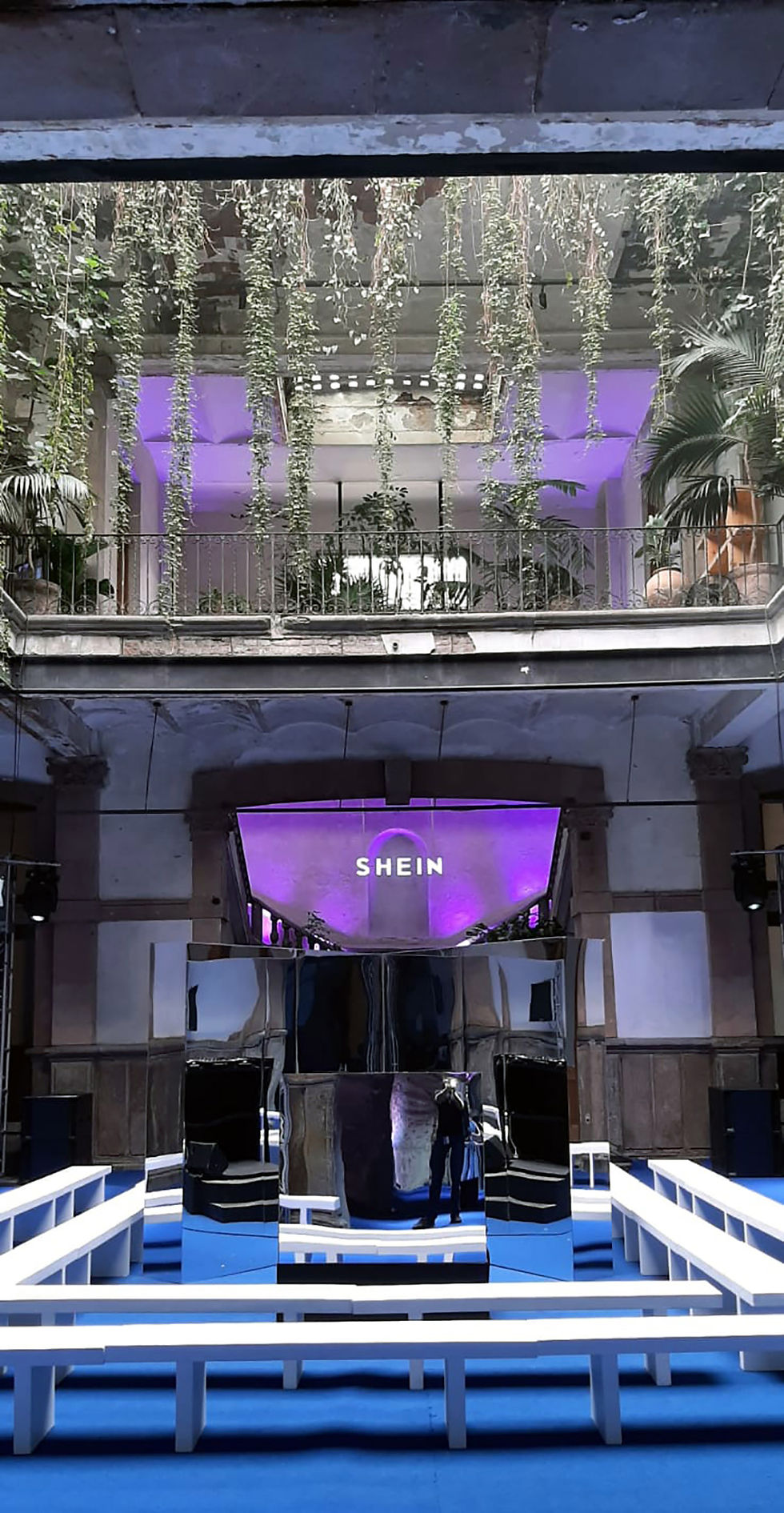 booth para Dj terminado espejo con branding de la marca en letras luminosas, alfombra y bancas blancas e iluminación