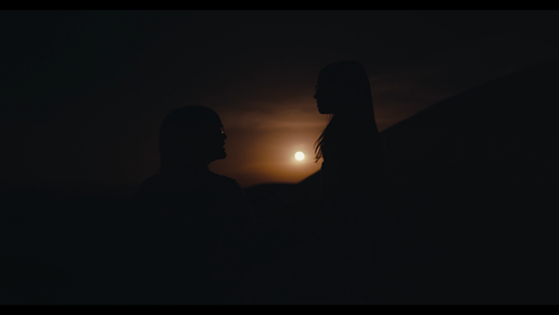 Photo d'un coucher de soleil en fond avec une femme et une petite fille qui se regardent. 
