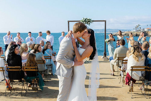 bride and groom kiss at the end of aisle at the ceremony.