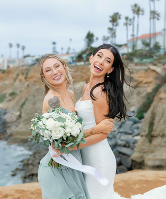 Bride with her bridesmaids having fun at sunset cliffs.