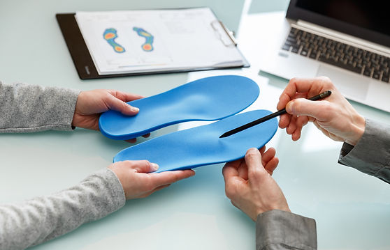 Doctor consulting patient on custom orthotic insoles in a clinic for a personalised custom