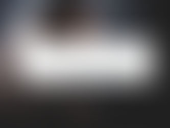 a man praying with his head down, hands clasped and his elbows resting on a Bible