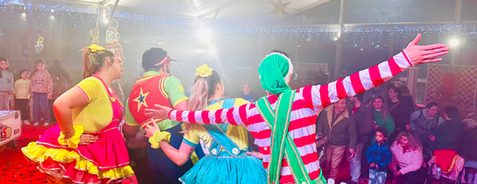 Espetáculo infantil profissional do Palhaço Sorriso com bailarinos no palco
