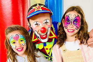 Palhaços e crianças com lindas pinturas faciais em evento infantil