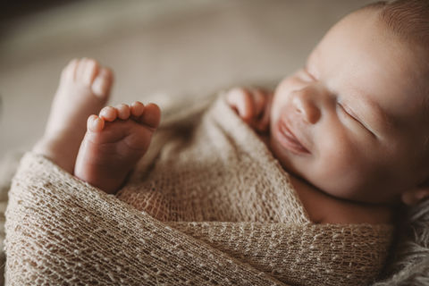 schlafendes Neugeborenes im Nestchen. Eingepuckt.