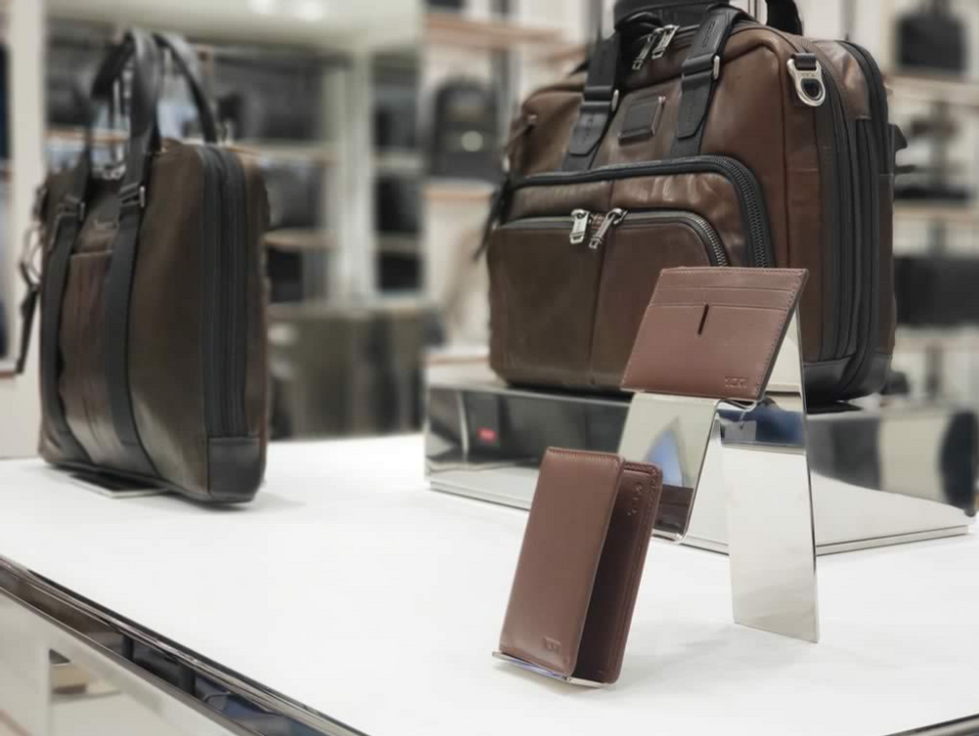 Nesta cena de exposição de acessórios de luxo, o uso estratégico de superfícies metálicas cria um jogo de reflexos que eleva a percepção de valor de cada peça.