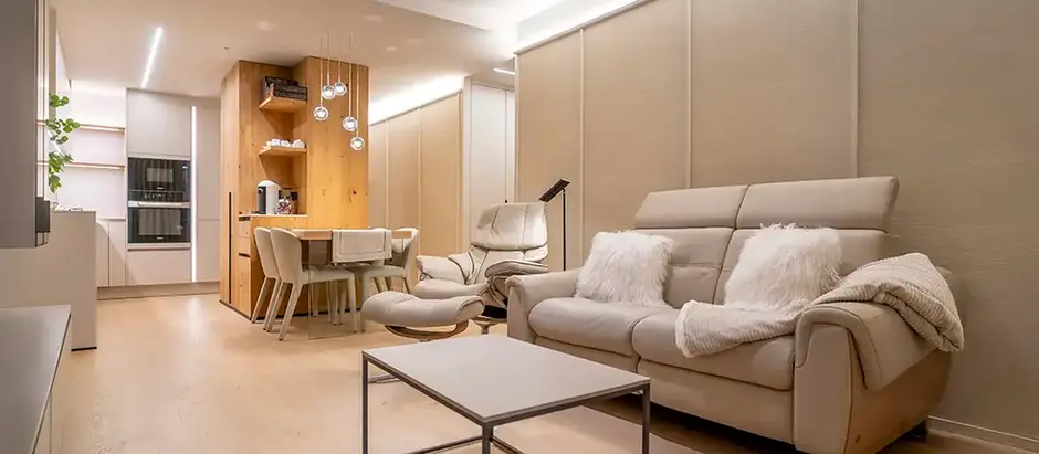 Modern living room with beige furniture and warm lighting.