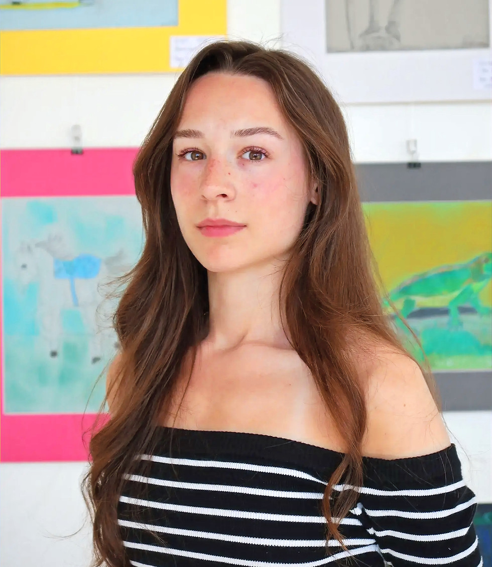 Studio artist standing in front of displayed artwork