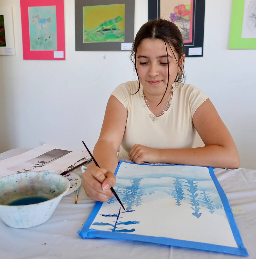 Young girl painting a landscape with a brush