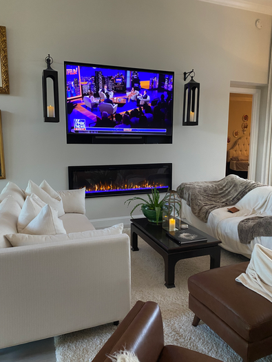 Modern living room with a wall-mounted flat-screen TV and elegant sofas.