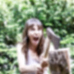 Angry woman hitting log with an axe