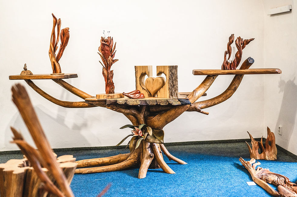 Výstava dřevěnách soch a dekorací Jiřího Hlávky v Zásmukách na zámku 2024 - ručně vyřzaný stůl a dekorace.