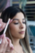 Maquilladora aplicando sombras a una mujer en La Biblioteca.