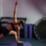 Mujer practicando yoga con bloque en gimnasio