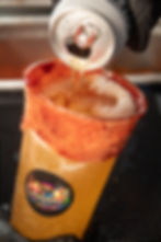 Vertiendo cerveza en vaso de michelada con borde de chile