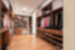 Vestidor de madera con ropa y zapatos organizados