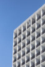 Fachada moderna de edificio blanco con balcones y cielo azul