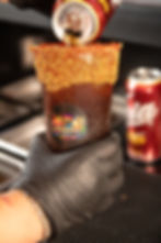 Vaso de michelada con borde de ajonjolí y logo de Drinkers.