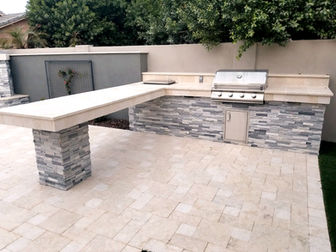 custom grill and outdoor kitchen with unique seating feature.