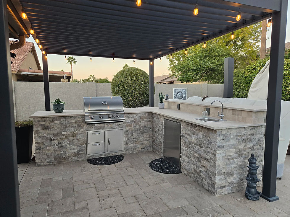Modern outdoor kitchen with grey stacked stone, bbq grill and sink area