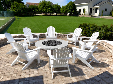 Backyard fire pit area with Adirondack-style chairs